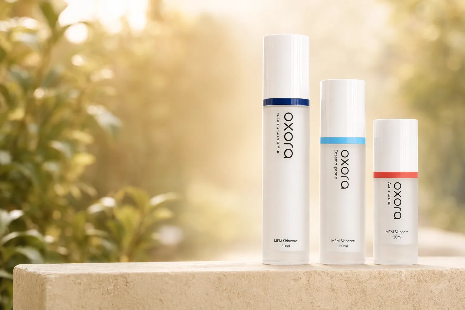Oxora Acne-prone, EP, and EP Plus on a stone ledge, warm garden bokeh behind